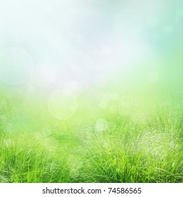 Spring Or Summer Abstract Nature Background With Grass And Bokeh Lights. Blue Sky In The Back