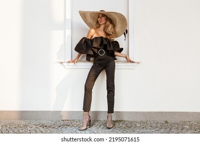 Spring, Summer Fashion. High Fashion Model. Glamour, Stylish Elegant Woman In Black Jumpsuit And Big Hat. Female Model In Stylish Look In The City. Travel Model. Outdoor Shoot. Vogue. Elegance.