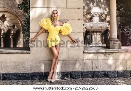 Spring, summer fashion. High fashion model. Glamour, stylish elegant woman. Female model in amazing yellow dress in the city. Travel model. Outdoor shoot. Elegance. Vogue.