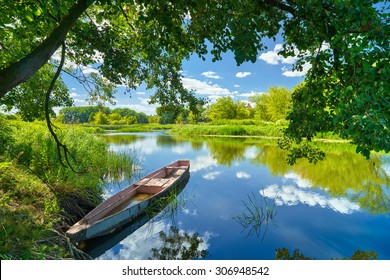 Spring summer landscape blue sky clouds Narew river boat green trees countryside grass Poland water leaves - Shutterstock ID 306948542