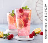 Spring or summer refreshing cold cocktail or mocktail with berries and lemon, raspberry lemonade