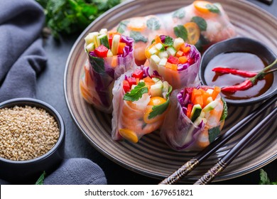 Spring Or Summer Rolls With Rice Paper, Carrot, Chili Sauce, Red Cabbage, Zucchini , Pepper, Shrimps And Kumquats. Tasty Asian Food.