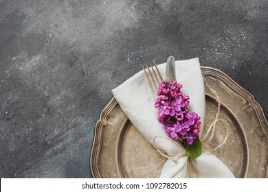 Spring table place setting with romance violet lilac, silverware on vintage table. Top view. Copy space. - Powered by Shutterstock