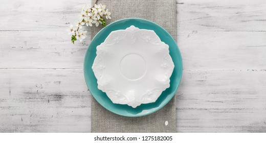 Spring table set with plates and blooming white flowers branch. top view with copy space