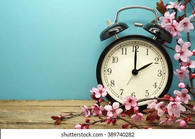 Spring Time Change / Pink Blossoms and an Alarm Clock on an Old Wooden Table - Shutterstock ID 389740282