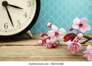 Spring Time / Pink Blossoms And An Alarm Clock On An Old Wooden Table