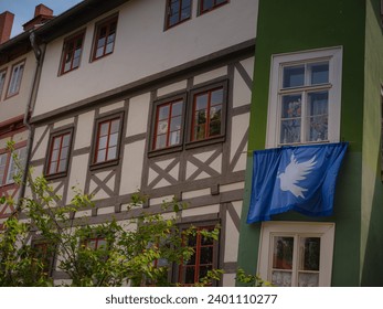 spring trip to Europe. scenic view to facade of old historic houses somewhere in Erfurt city, blue flag with a dove of peace that residents of house hung on their facade - Powered by Shutterstock