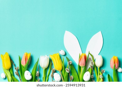 Spring tulips with Easter eggs and white bunny ears on a turquoise background. A festive and cheerful Easter concept.