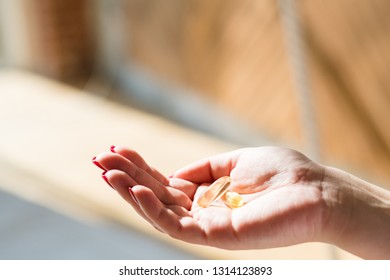 Spring Vitamin Deficiency. Woman Hand Holding Fish Oil Supplement.