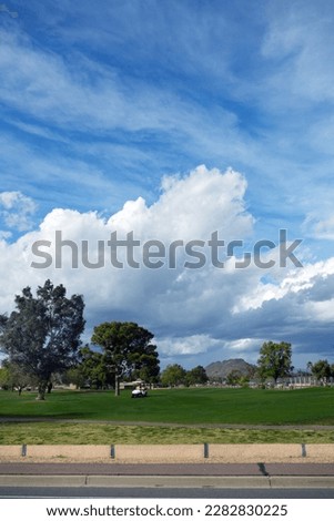 Spring weather front moves in over city golfcourse as seen from a public street, Phoenix, Arizona