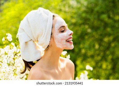 Spring Woman With Facial Mask. Clean Fresh Skin Touch Own Face. Care And Tendetness. Beauty And Healthcare. Spring Background. Portrait Of Beauty Woman Smiling With Towel On The Head