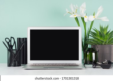 Spring Workplace With Blank Notebook Screen, Black Stationery, Books, Candlestick, White Fresh Flowers, Aloe In Elegant Green Mint Menthe Interior On White Wood Table.