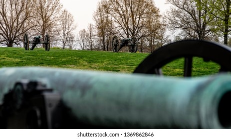 Springfield, MO—April 11, 2019; Two Civil War Era Cannons On Hill Top With Bronze Barrel Of Another Blurred In Foreground At Wilsons Creek National Battlefield Park In Spring.