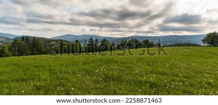 Springtime mountain meadow with trees on Brst hill and hills on the background above Bela pod Pradedm village in Jeseniky mountaiins in Czech republic
