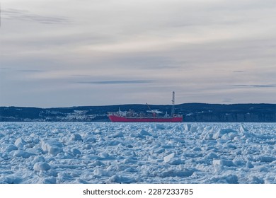 Springtime ocean ice has surrounded an oil production and storage vessel creating risk, Newfoundland and Labrador, Canada. Thick heavy ice that moves with the wind and tides.