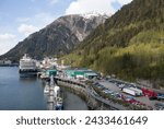 The springtime view of a cruise ship moored in Juneau town port and Juneau Mountain in a background (Alaska).