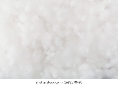 Springy clean white hollow fiber. Holofiber closeup texture. Non-woven synthetic textile