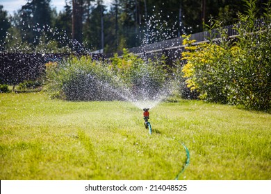 Sprinkler In Garden Watering The Lawn