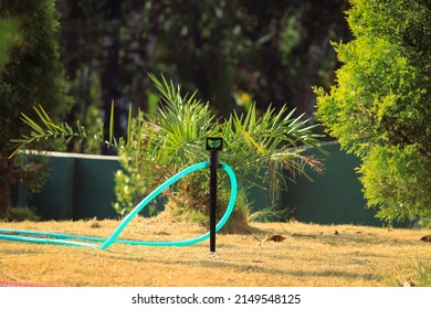 Sprinkler And Pipe In Dry Garden. Waiting For Water. Nature. Summer Garden Maintenance.