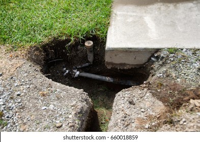 Sprinkler Repair.  Fixing An Automatic Sprinkler System. Attaching New Pipe To An Existing Line After It Has Been Dug Up Near Driveway.