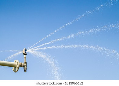 Sprinkler system sprays water against the sky - Shutterstock ID 1813966652