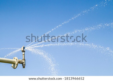 Sprinkler system sprays water against the sky