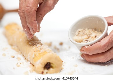 Sprinkling Nuts Over The Rolled Up Strudel Dough