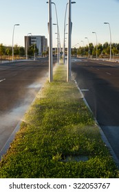 Sprinkling On Grass Median An Urban Avenue, At Dawn 