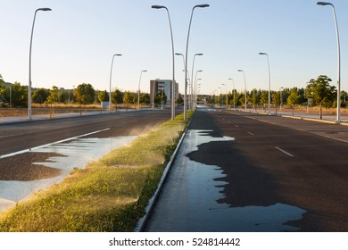 Sprinkling On Grass Median An Urban Avenue, At Dawn