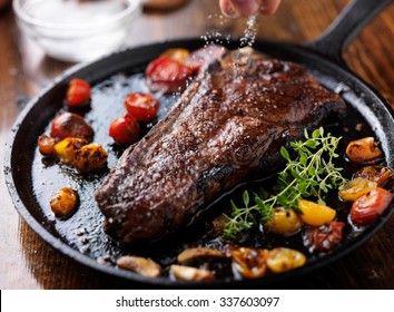 Sprinkling Sea Salt On A Ny Strip Steak Cooked In A Iron Skillet