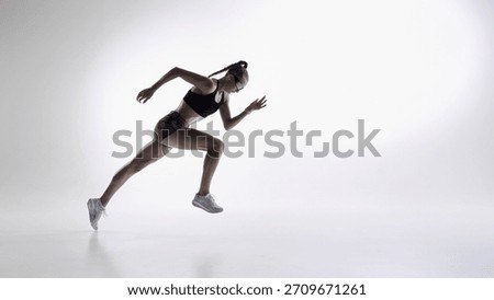 Sprinter accelerating in mid-air during powerful studio run sequence. Concept of performance coaching, sports biomechanics, training programs, athletic tests, and speed development.
