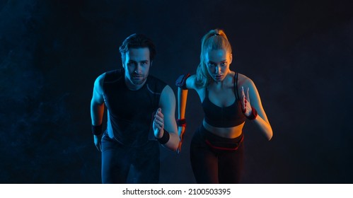 Sprinter Run. Strong Athletic Woman And Man Running On Black Background Wearing In The Sportswear. Fitness And Sport Motivation. Runner Concept.