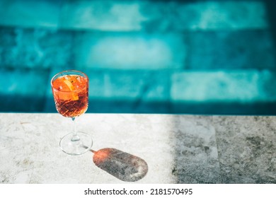 Spritz Cocktails On Poolside. Background Of Shining Blue Clear Water In Swimming Pool.