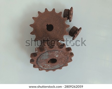A sprocket that appears rusty. This component is commonly used in agricultural equipment, conveyors, or other heavy machinery.