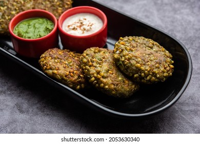 Sprouted moong dal tikki or patties is a healthy snack from India served with green chutney and curd