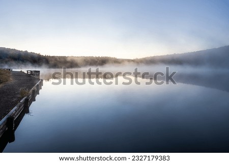 Spruce Knob Lake in Appalachian mountains West Virginia fog mist sunrise morning hiking trail path to fishing deck in Monongahela National Forest autumn fall season