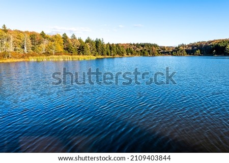 Spruce Knob lake blue water surface ripples in West Virginia WV Appalachian mountains sunset in Monongahela National Forest late autumn fall season foliage reflection
