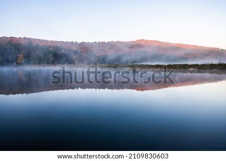Spruce Knob lake hiking trail in Appalachian West Virginia mountains fall autumn season and fog mist sunrise morning in Monongahela National Forest sunlight on trees foliage