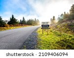 Spruce Knob West Virginia mist fog autumn fall season and sign on empty road in morning for highest point in Monongahela national forest Appalachian Allegheny mountains