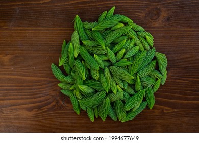 Spruce Tips In A Pile On Wood Background