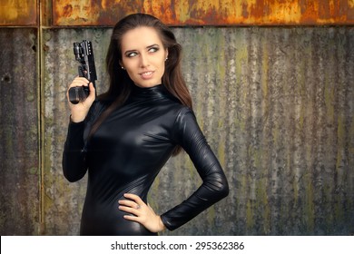 Spy Agent Woman In Black Leather Suit Holding Gun - Portrait Of A Super Heroine In Action
