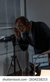 A spy with a headset and a camera peeks through the window for covert surveillance.