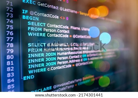 SQL (Structured Query Language) code on computer monitor and server room background. Example of SQL code to query data from a database. 