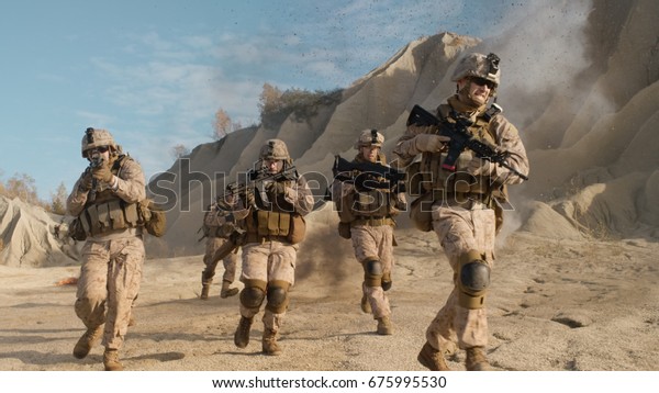 Squad of Fully\
Equipped, Armed Soldiers Running and Attacking During Military\
Operation in the Desert.