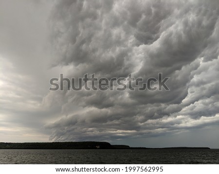 Squall line storm rolling in over a lake.