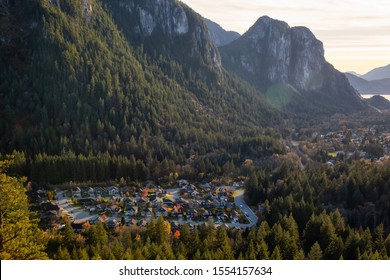 Squamish, North of Vancouver, British Columbia, Canada. Beautiful View from the top of the Mountain of a small town surrounded by Canadian Nature during Autumn Sunset.