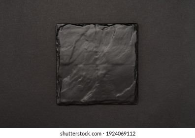 square black slate board or plaque for menu or recipe text on black table. Mockup Blank board on black table background. minimalistic design. space for text