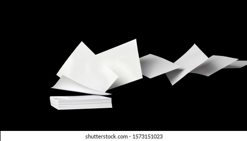 Square blank white papers flying away from a stack in the wind, on black - Powered by Shutterstock