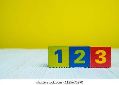 Square Block Puzzle Number 1 2 And 3 On Table With Yellow Wall Background