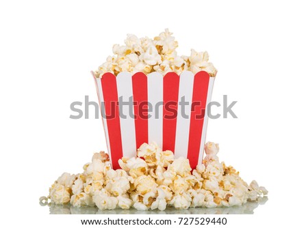 Square box filled with popcorn, part scattered, isolated on white background